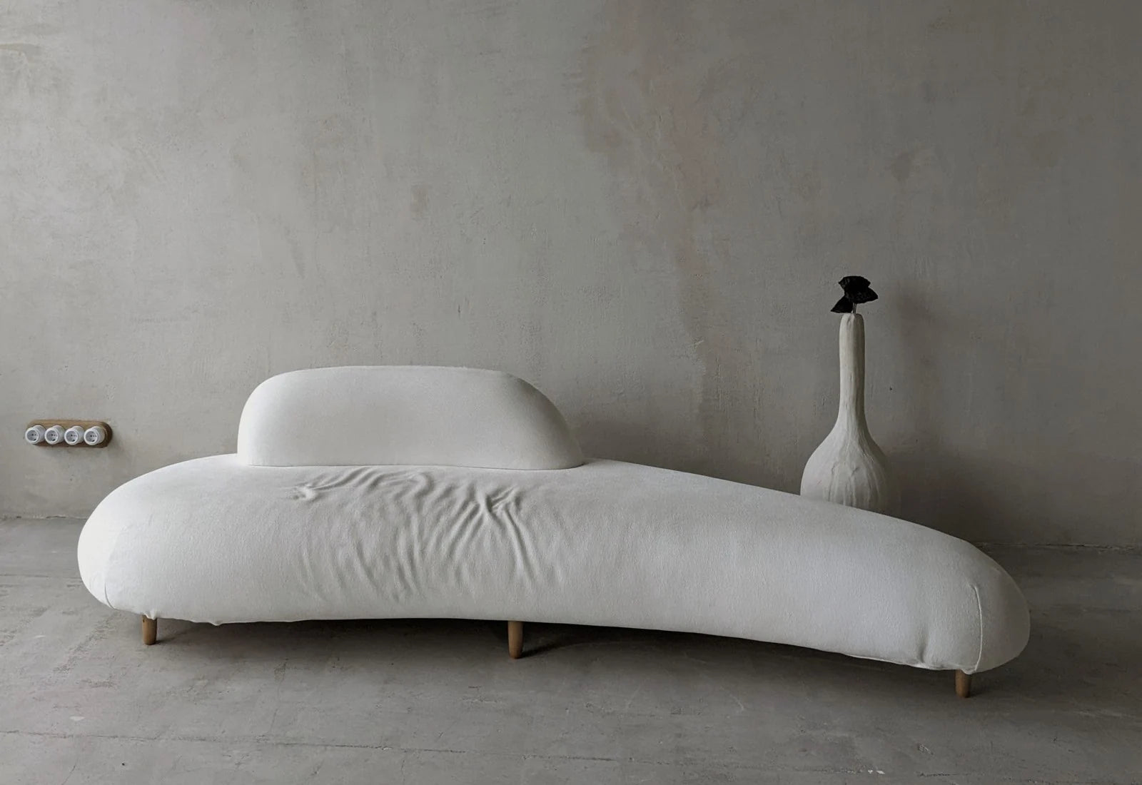 Photographic showroom: neutral wall above a white sofa.